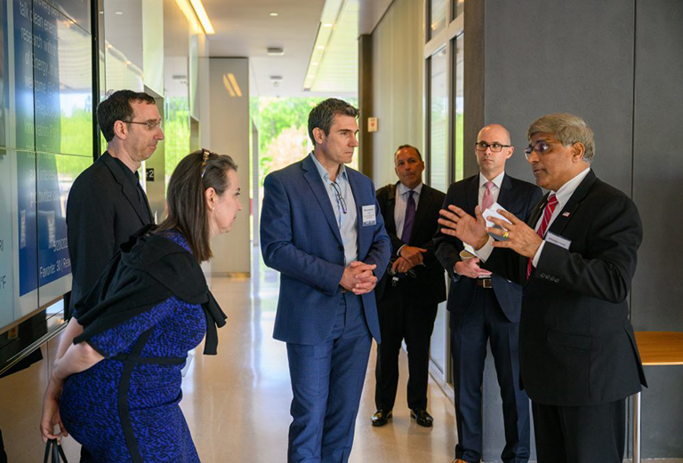 photo of Sethuraman Panchanathan, right, director of the National Science Foundation, speaks with Ofer Harel, left, associate dean and professor of statistics, Anne D'Alleva, interim provost, and Emmanouil Anagnostou, interim executive director, during a tour of the Innovation Partnership Building on May 23, 2022. (Peter Morenus/UConn Photo)